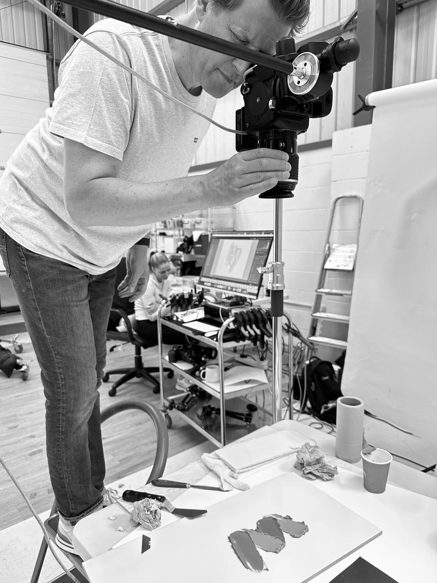 A photographer adjusting a camera above a product set in the PMP studio.